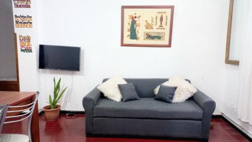 sala de estar con sofá y TV en CÉNTRICO Alojamiento Dpto Gchu c COCHERA Precio en Dólares USD consulte Valor expresado en dol es lo q se cobra en Gualeguaychú