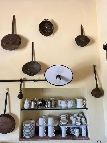 Eine Küche mit Töpfen, Pfannen und Geschirr an einer Wand in der Unterkunft Tenuta Aguglia in Noto