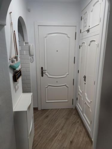 baño con puerta blanca y suelo de madera en Apartamento Ohana, Costa del Sol en Algarrobo-Costa