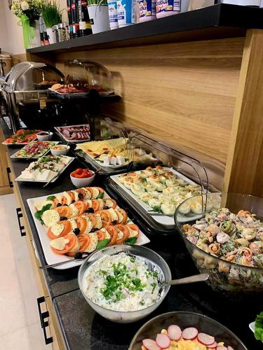 Una línea de buffet con muchos tipos diferentes de comida. en Villa Cristal, en Świnoujście