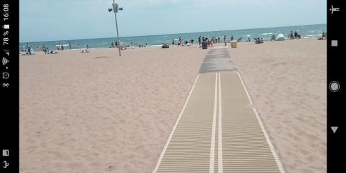 a boardwalk on a beach with people on it at Valras-Plage, les sables du midi ,mobil home in Sérignan