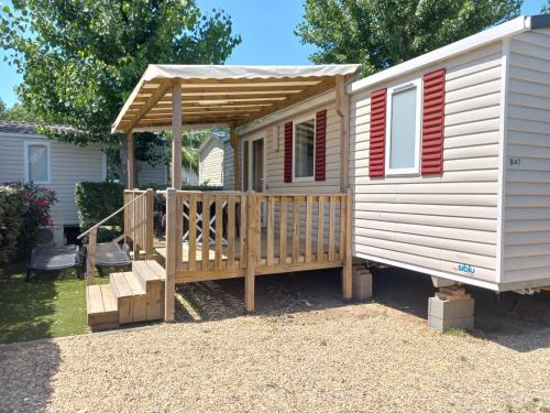 eine Hütte mit einer Veranda und einer Holzterrasse in der Unterkunft Valras-Plage, les sables du midi ,mobil home in Sérignan