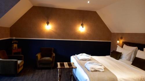 ein Hotelzimmer mit einem Bett und einem Stuhl in der Unterkunft Chambres d'hôtes - Au Clos d'Amande in Lasne