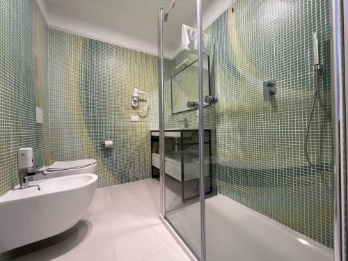 een badkamer met een douche, een toilet en een wastafel bij HOTEL MOSAICO in Matera