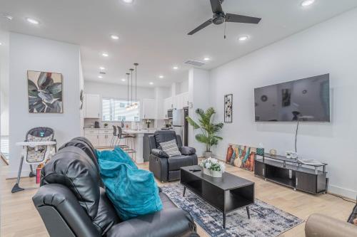 a living room with leather furniture and a tv at Cozy Duplex Mins to DT/ MCTR, free wi-fi/ Parking in Houston