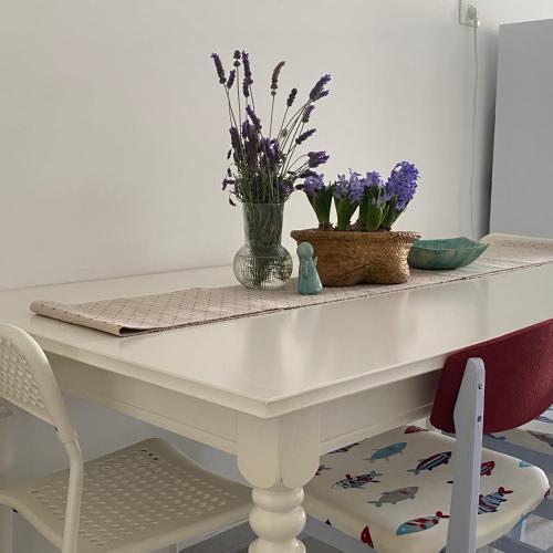 a white dining room table with flowers on it at יפעת הגלבוע -סוויטות אירוח ברמה אחרת in Nurit