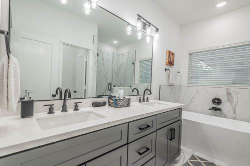 a white bathroom with a sink and a tub at Cozy Duplex Mins to DT/ MCTR, free wi-fi/ Parking in Houston