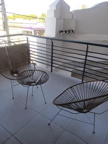2 stoelen en een tafel op een balkon bij Temporario 2 habitaciones in Cañada de Gómez