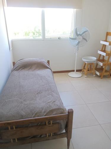 una camera con letto, ventilatore e finestra di Temporario 2 habitaciones a Cañada de Gómez
