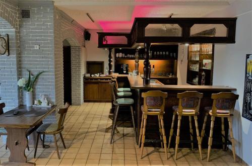 un restaurante con bar con taburetes en una habitación en Hotel am Hafen en Brunswick