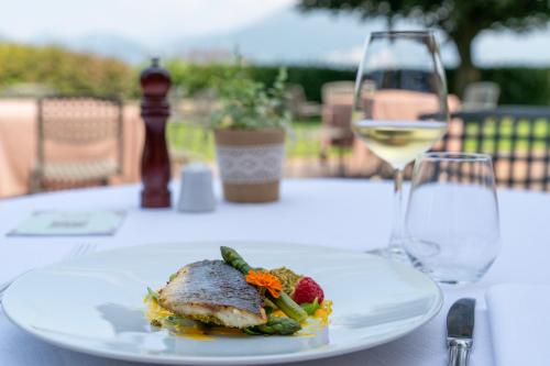 a plate of food on a table with a glass of wine at La Corte di Lurago in Lurago D'Erba 