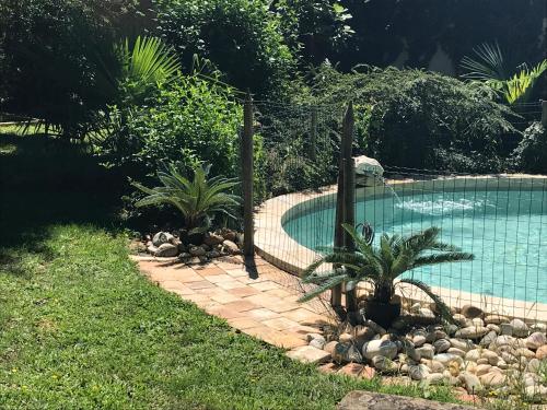 a swimming pool in a yard with plants and a fence at Phèdre en Saône in Genouilleux