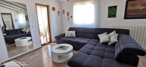 sala de estar con sofá azul y mesa en Apartment Brioni Sea,Garden,Poll view 2 plus 2 80m2 tiki bar, en Peroj