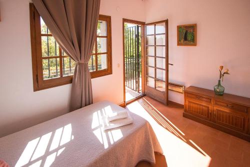 een slaapkamer met een bed en 2 ramen bij Catalunya Casas: Spacious Villa Vera up to 24 guests, a short drive to Blanes! in Girona