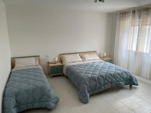 a bedroom with two beds and a window at Giardino Sud - a pochi passi dal mare in San Vincenzo