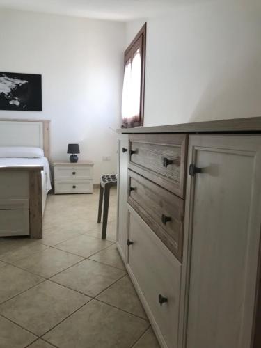 a bedroom with a dresser and a bed with a window at Domu Bonora in Pula
