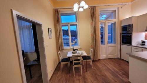 eine Küche und ein Esszimmer mit einem Tisch und Stühlen in der Unterkunft Apartmán U kolonády in Marienbad