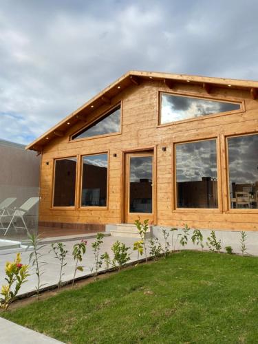 ein Holzhaus mit Fenstern und einem Hof in der Unterkunft أكواخ وشاليهات باشن الريفية in Khalij Salman