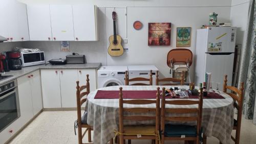 cocina con mesa, sillas y nevera en Astrofegia Apartments Near The Sea, en Ayia Marina