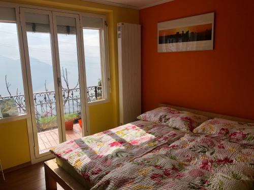 a bedroom with a bed in front of a window at Inspiration über dem See in Locarno