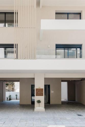 a large white building with a plant in the middle at ESTEA Quality Living in Volos
