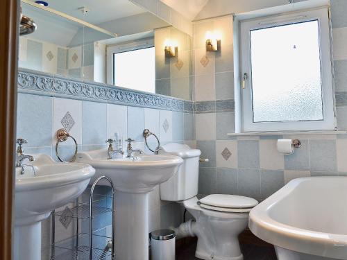 ブロードフォードにあるIsle View - 28284のバスルーム(洗面台2台、トイレ付)、窓が備わります。