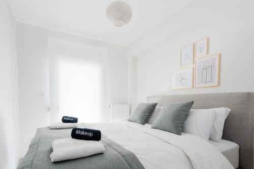 Un dormitorio con una gran cama blanca con una caja negra. en ESTEA Quality Living, en Volos