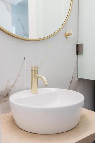 a white sink in a bathroom with a mirror at ESTEA Quality Living in Volos