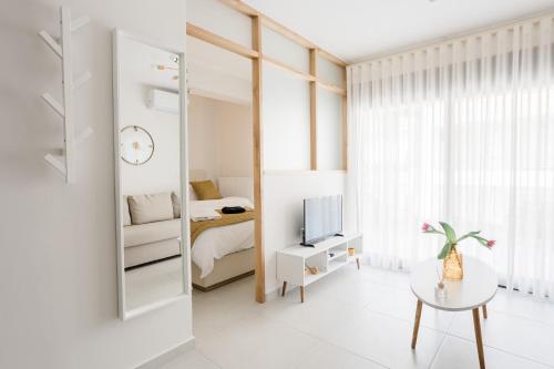 a small white room with a bed and a mirror at ESTEA Quality Living in Volos