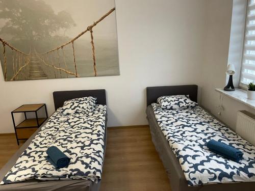 dwa łóżka siedzące obok siebie w sypialni w obiekcie Pokoje KEN w Warszawie