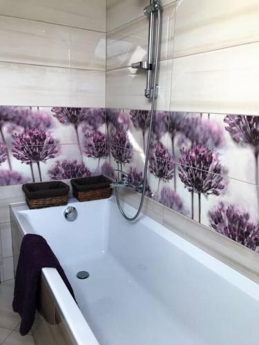baño con ducha con flores púrpuras en la ventana en Domek nad Wisłą, en Ustroń