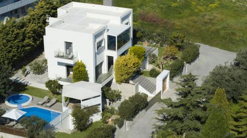 an aerial view of a white house with a swimming pool at Kastellakia Executive Villa in Rethymno