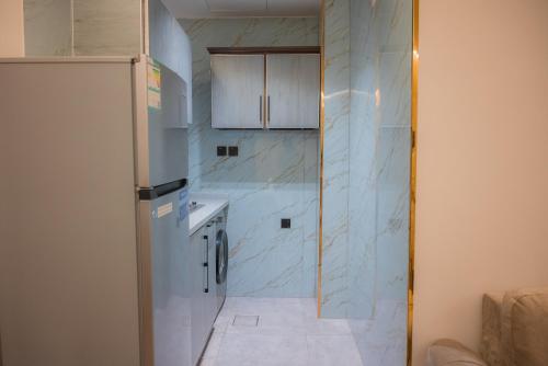 a kitchen with a refrigerator and a tile floor at فندق بلاتينيوم الاولي الفندقية in Al Madinah