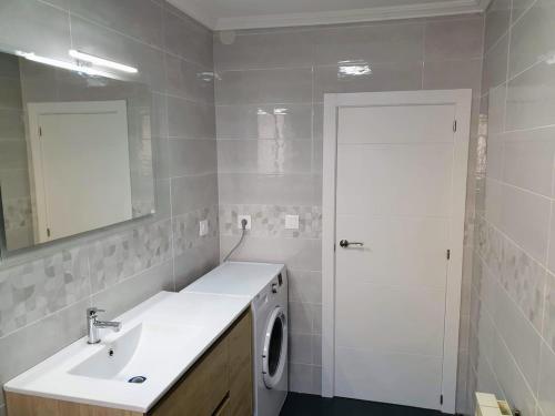 a bathroom with a sink and a washing machine at Aviles vut 1963 as in Avilés