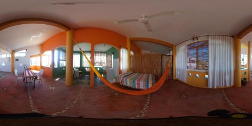 a room with a hammock in a house at El Tucan in Puerto Escondido