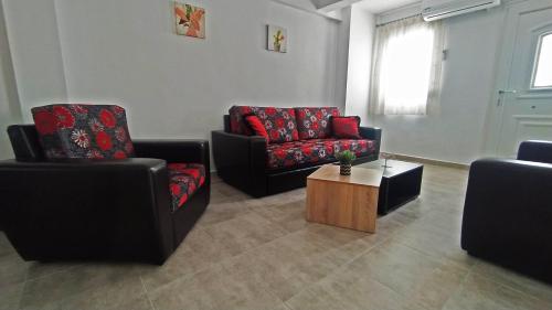 a living room with two chairs and a coffee table at Cozy ground floor house in Agia Triada