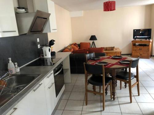 a kitchen and living room with a table and chairs at Joli T3 en Centre Village de Tallard in Tallard
