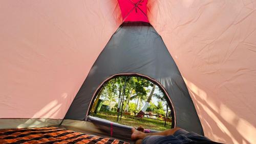 een persoon ligt in een tent bij Stay On The Way Resort Mandwa Alibag in Alibaug