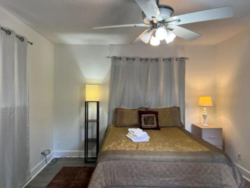 um quarto com uma cama e uma ventoinha de tecto em Comfy Beautiful 3 bedroom Home in Jacksonville em Jacksonville