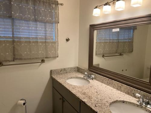 uma casa de banho com 2 lavatórios e um espelho em Comfy Beautiful 3 bedroom Home in Jacksonville em Jacksonville