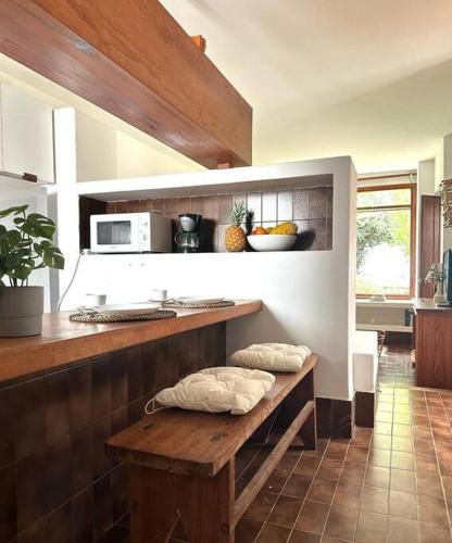 a kitchen with a wooden bench in a kitchen at Casa mar y jardín: tranquilidad y vistas únicas in Los Cancajos