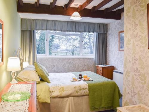 sypialnia z łóżkiem i oknem w obiekcie Woodbine Cottage w mieście Ludham