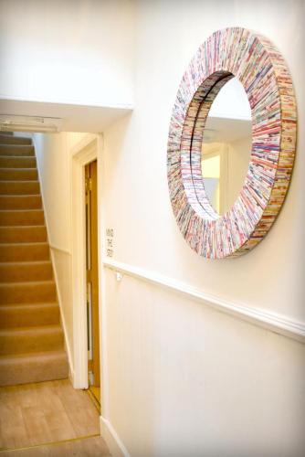 a mirror on the wall of a hallway with a staircase at The ‘Servants Quarters@Delny House’ in Invergordon