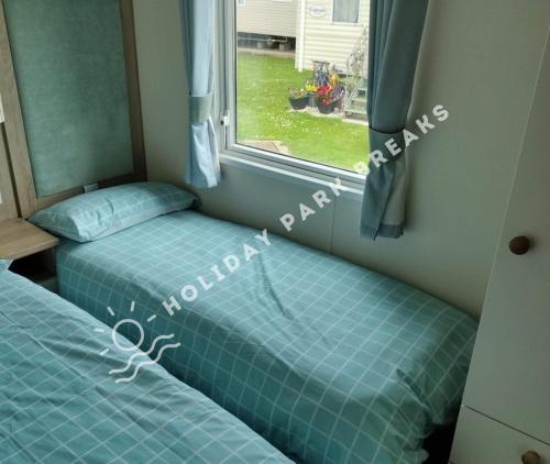 Spacious 3 bed @ Seal Bay Resort (Bunn Leisure) في سيلسيه: سريرين توأم في غرفة مع نافذة