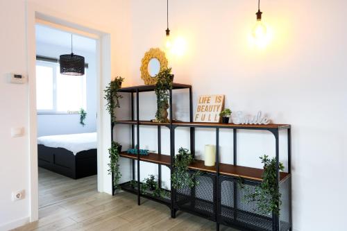 un salon avec une étagère et des plantes dans l'établissement Sweet Escape- 1BR in Pipera, à Voluntari