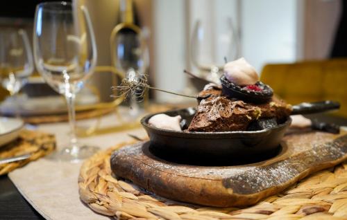a dessert in a bowl on a table with wine glasses at Tolevski Apartments, Bitola in Bitola