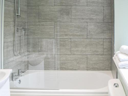 a bathroom with a white tub and a shower at Addycombe Cottage in Rothbury