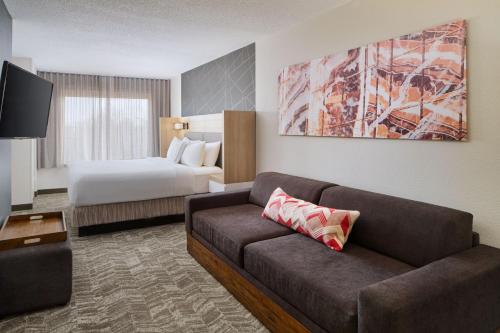 um quarto de hotel com um sofá e uma cama em SpringHill Suites Edgewood Aberdeen em Bel Air