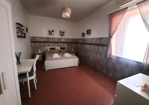 a bedroom with a bed and a table and a window at B&B Iolì Vesuvio in Ercolano