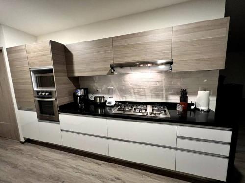a kitchen with white cabinets and a stove top oven at Luxury 4BR Apartment w Pool, Spa & Stunning Views in Puebla